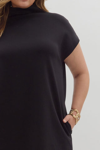 Black turtleneck dress worn by a person on a light gray background