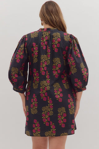 Woman wearing a floral dress with puff sleeves on a plain background