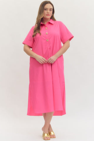 Woman wearing a pink dress with gold buttons on a white background