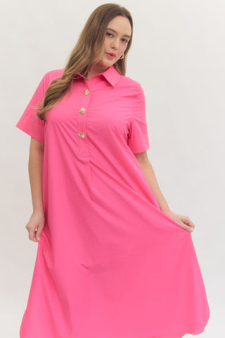 Woman wearing a bright pink dress with gold buttons on a white background