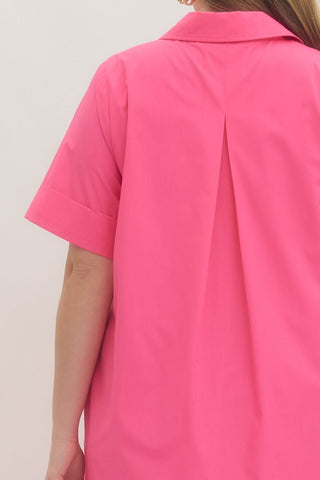 Close-up of a bright pink shirt worn by a person against a light background
