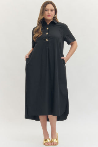 Woman wearing a black dress with gold buttons on a white background