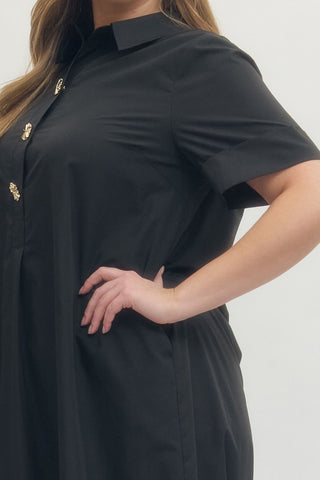 Black dress with gold buttons worn by a person on a white background