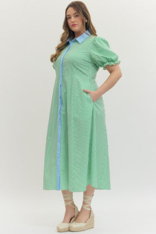 Woman wearing a green checkered dress with blue accents on a white background