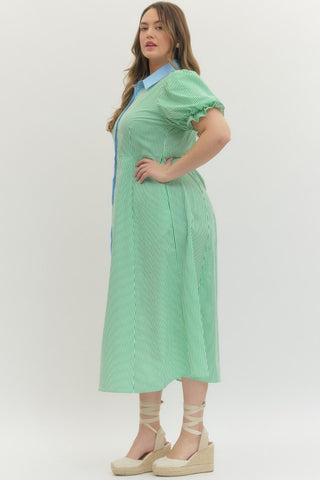 Woman wearing a green checkered dress with a blue collar on a white background