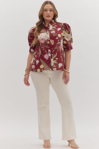 Woman wearing a floral blouse and beige pants on a white background