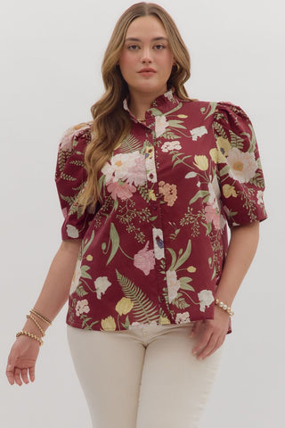 Woman wearing a floral blouse with puff sleeves on a white background
