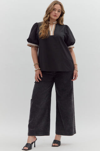 Woman wearing a black outfit with wide-leg pants on a white background
