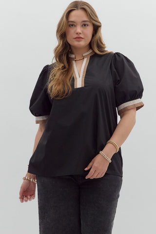 Woman wearing a black blouse with puff sleeves on a white background