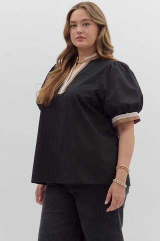 Woman wearing a black blouse with puffed sleeves on a white background