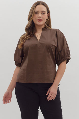 Woman wearing a brown blouse with puff sleeves on a white background