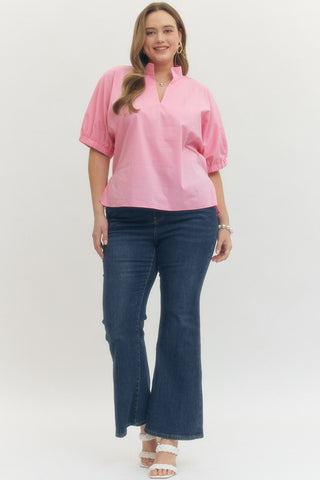 Woman wearing a pink blouse and blue jeans on a white background