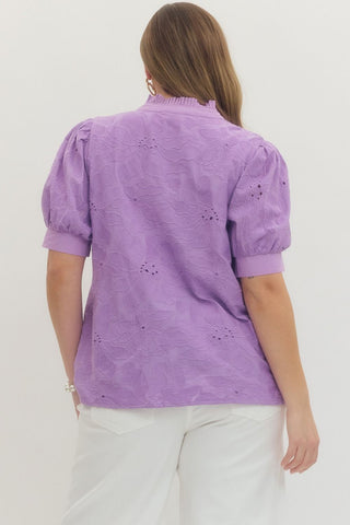 Woman wearing a purple blouse with puff sleeves on a white background