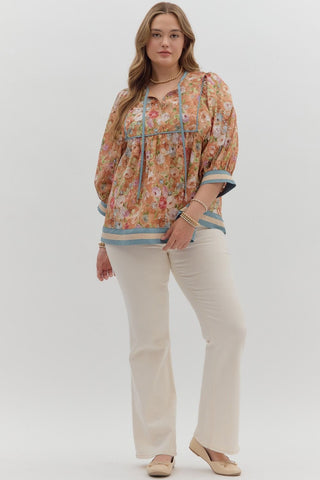 Woman wearing a floral blouse and beige pants on a white background