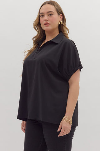 Woman wearing a black short-sleeve blouse against a white background
