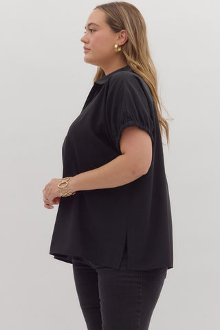 Woman wearing a black top and pants on a plain background