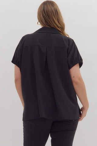 Person wearing a black short-sleeve shirt on a plain background
