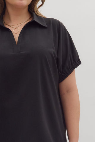 Black short-sleeve shirt worn by a person on a light gray background