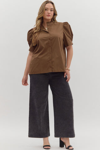 Woman wearing a brown blouse and black pants on a white background