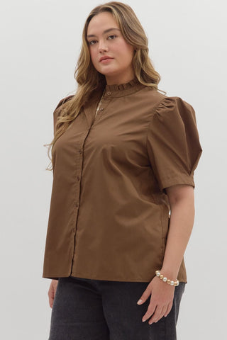 Woman wearing a brown blouse with puffed sleeves on a white background