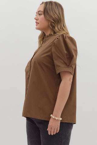 Woman wearing a brown blouse with short sleeves on a white background