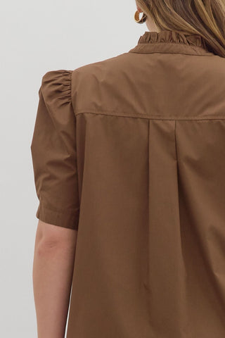 Brown shirt worn by a person on a plain background