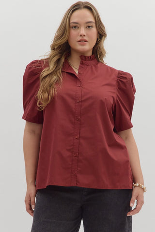 Woman wearing a red blouse with puff sleeves against a white background