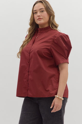 Woman wearing a red blouse with puff sleeves against a white background