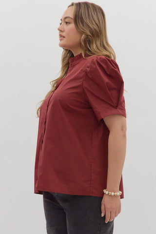 Woman wearing a red blouse with puff sleeves on a white background