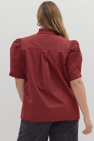 Person wearing a red blouse with puff sleeves on a white background