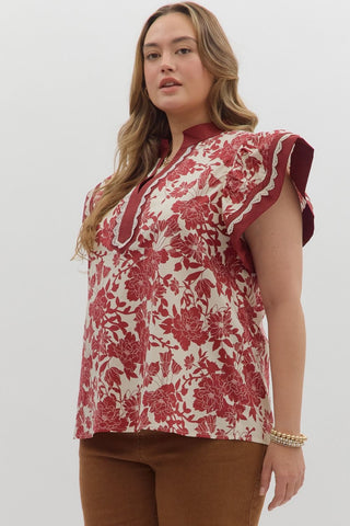 Woman wearing a red and white floral blouse against a white background
