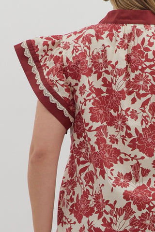 Red floral patterned shirt with lace trim on a plain background