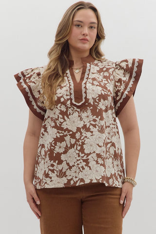 Woman wearing a floral blouse with ruffled sleeves on a white background