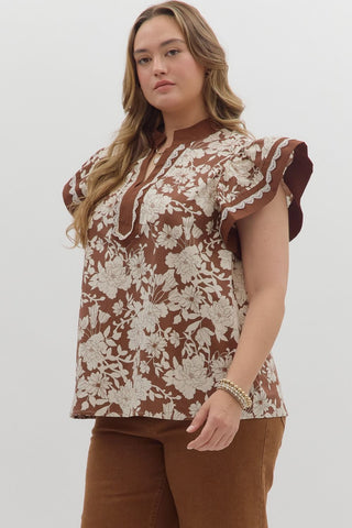 Woman wearing a floral blouse with ruffled sleeves on a white background