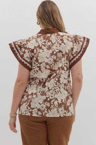 Woman wearing a floral blouse with ruffled sleeves on a white background
