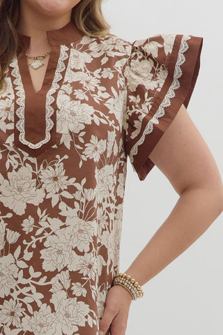 Woman wearing a floral blouse with ruffled sleeves on a white background