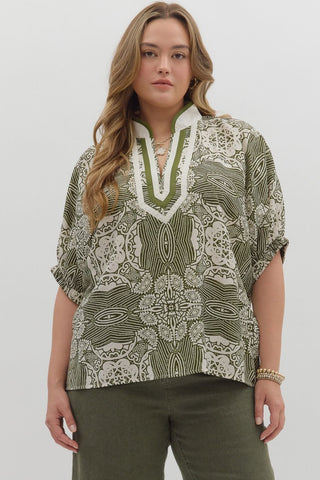 Woman wearing a patterned blouse and green pants on a white background