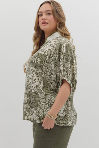 Woman wearing a patterned blouse with a plain background