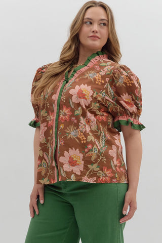 Woman wearing a floral blouse with puff sleeves against a white background
