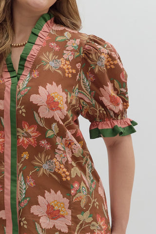 Floral dress with green trim on a plain background