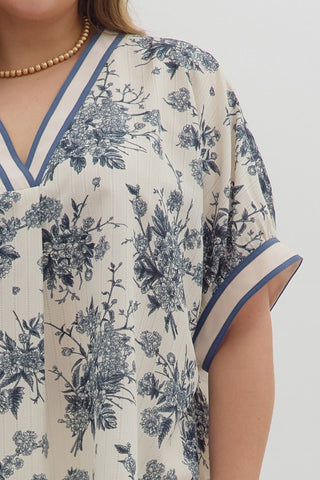 Beige dress with blue floral pattern on a plain background