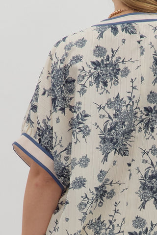 Close-up of a floral-patterned garment with blue accents on a plain background