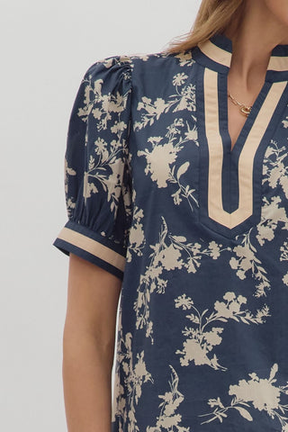 Navy blue dress with beige floral pattern on a plain background