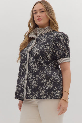 Woman wearing a dark floral blouse with a white background
