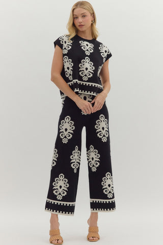 Woman wearing a black outfit with white patterns on a white background