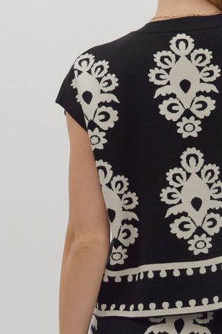 Black top with white pattern on a plain background