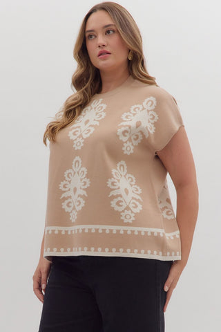 Woman wearing a beige top with white lace patterns on a plain background