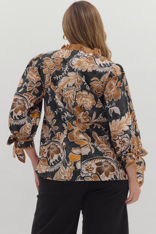 Woman wearing a patterned blouse with long sleeves on a white background