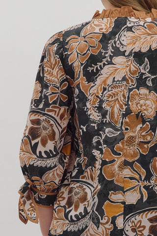 Floral patterned blouse with long sleeves on a plain background