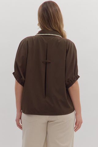 Woman wearing a brown blouse with a white background